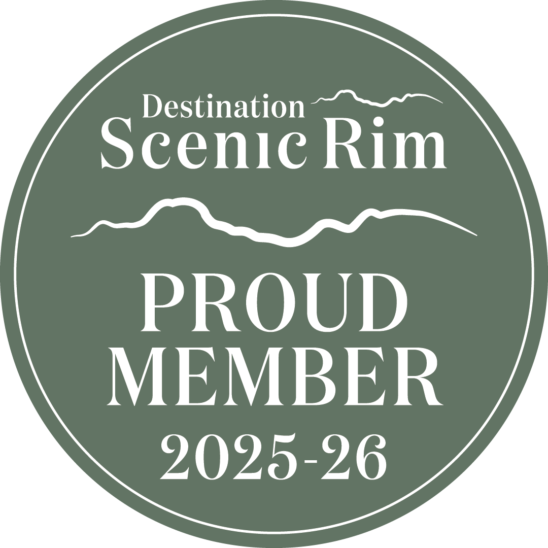 Circular badge with 'Destination Scenic Rim Proud Member 2025-26' text on a green background